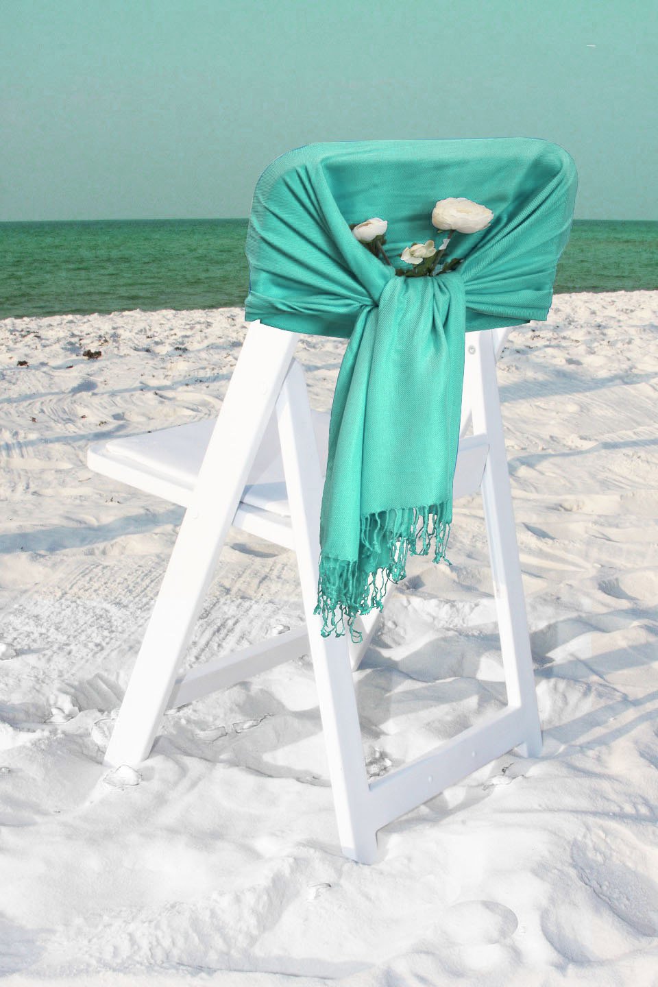 Turquoise silky pashmina-style shawl with fringed ends, wrapped over a chair.