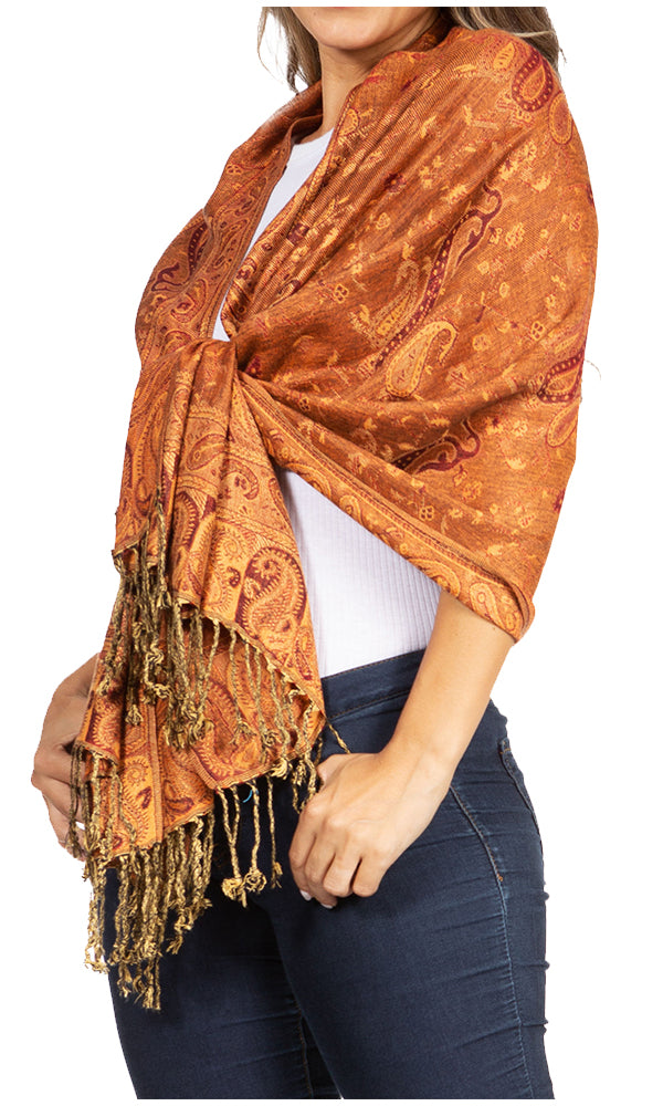 Sakkas double-layer paisley pashmina shawl in orange-rust with tassel fringe, over shoulder