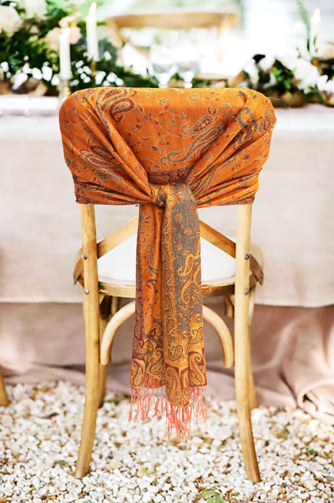 Orange paisley double-layer pashmina wrap with tassel fringe, draped over chair back