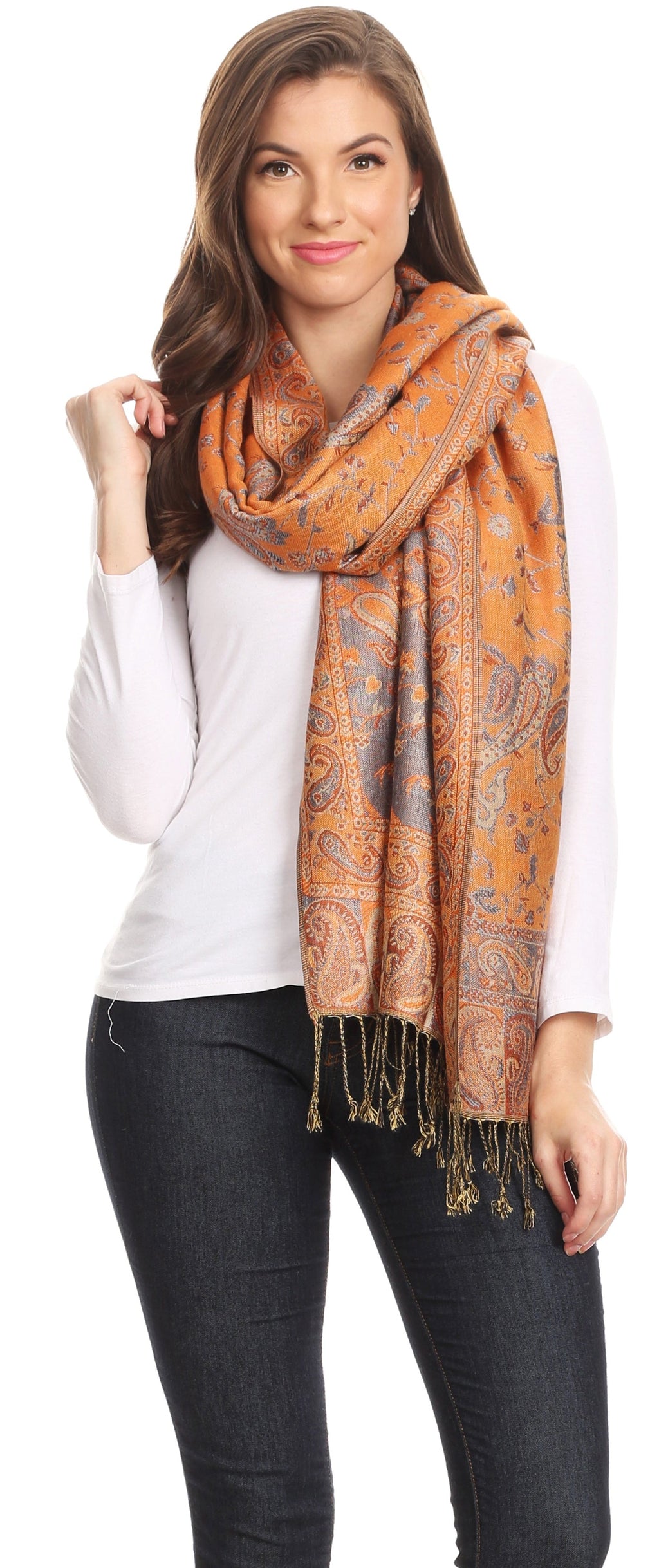 Orange paisley pashmina shawl draped around shoulders with long fringe ends