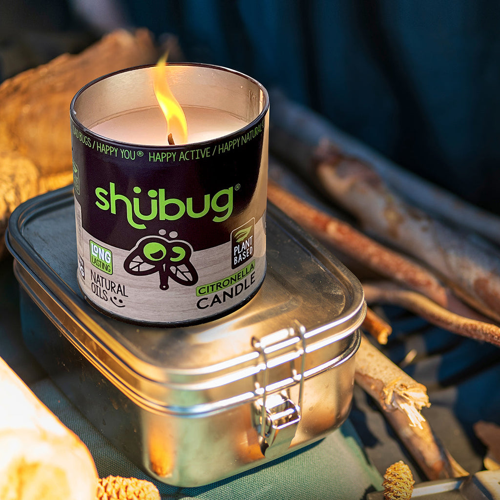 Burning Shubug citronella candle in metal tin with visible flame