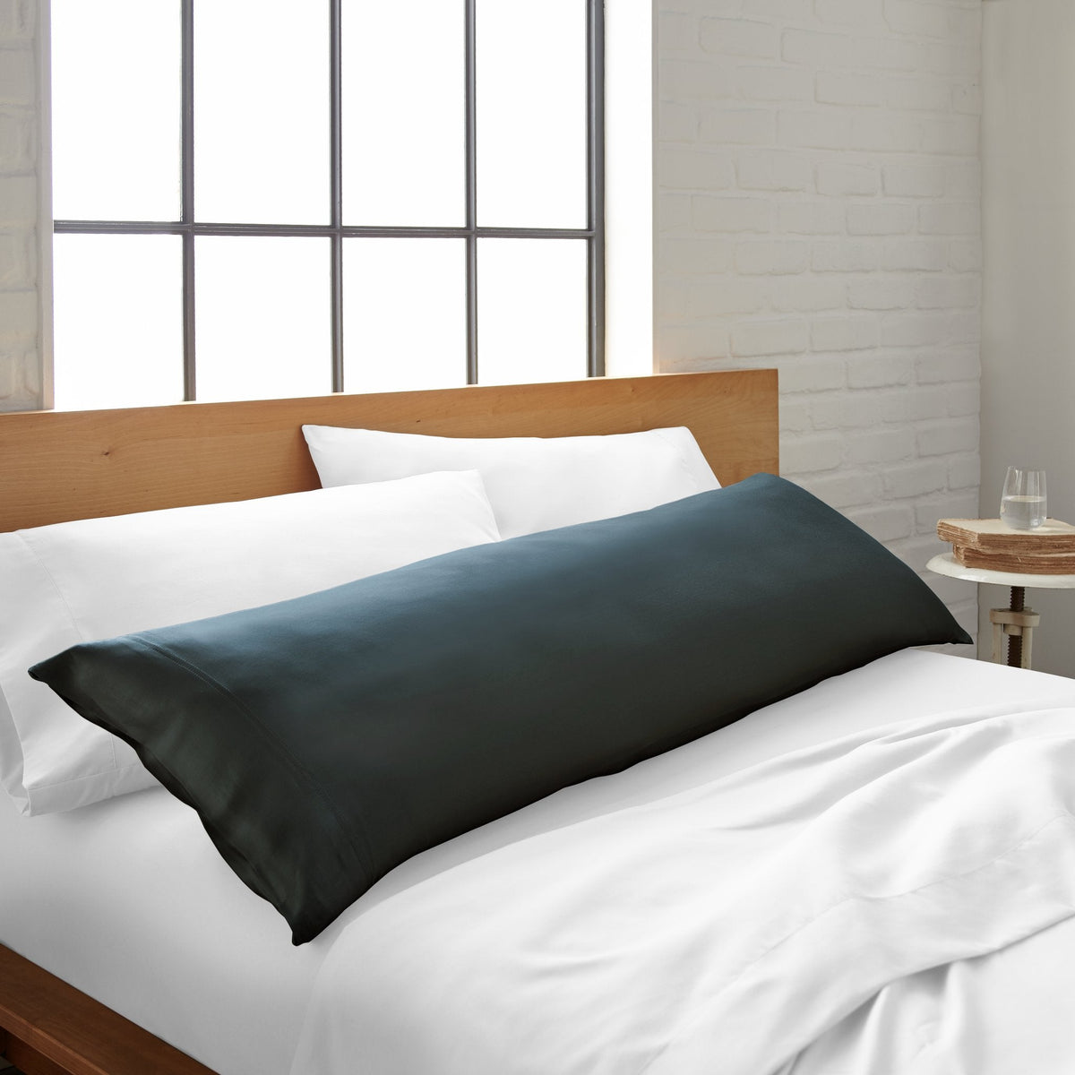 Dark slate body pillowcase with smooth fabric, lying on bed