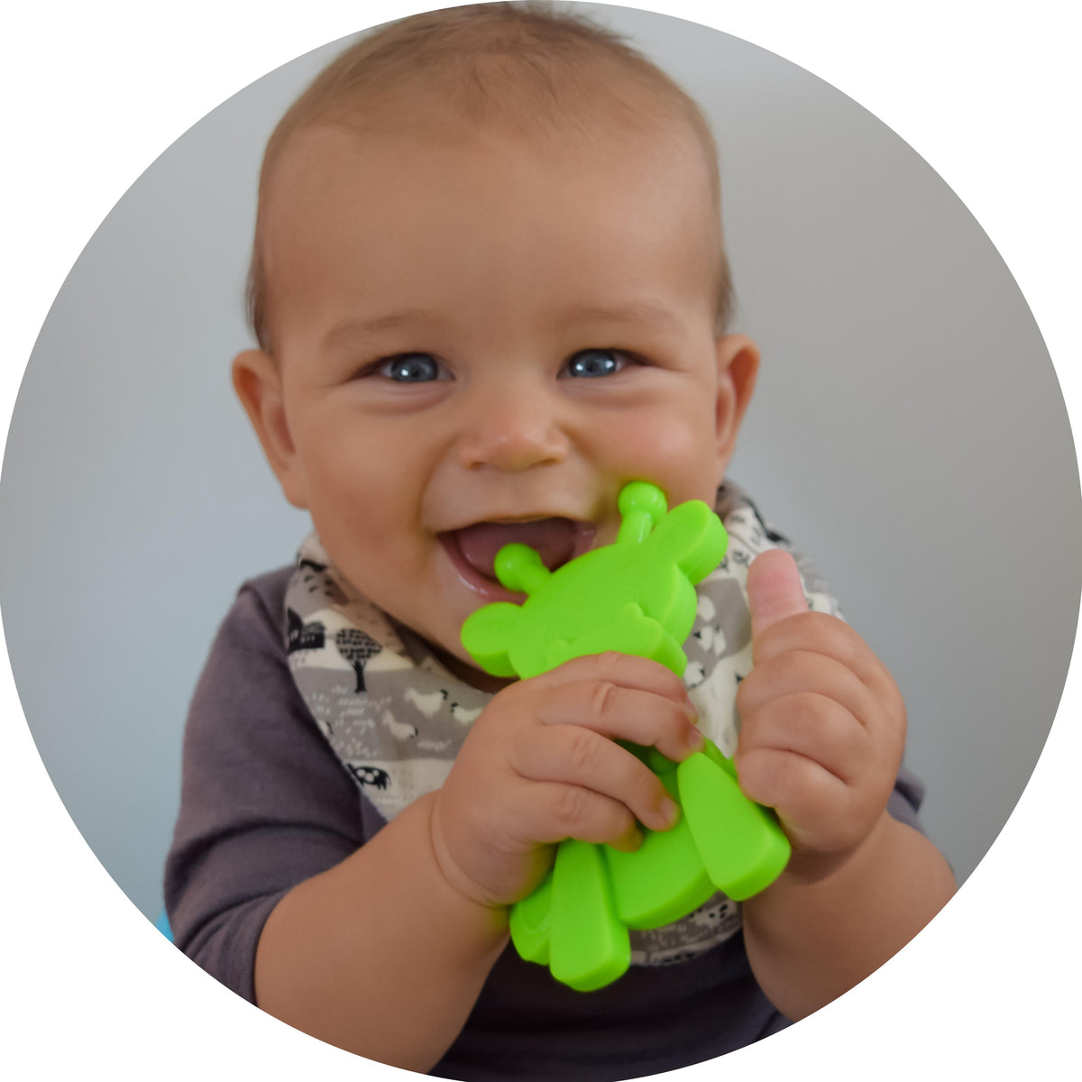 Baby chewing lime green giraffe-shaped teething toy