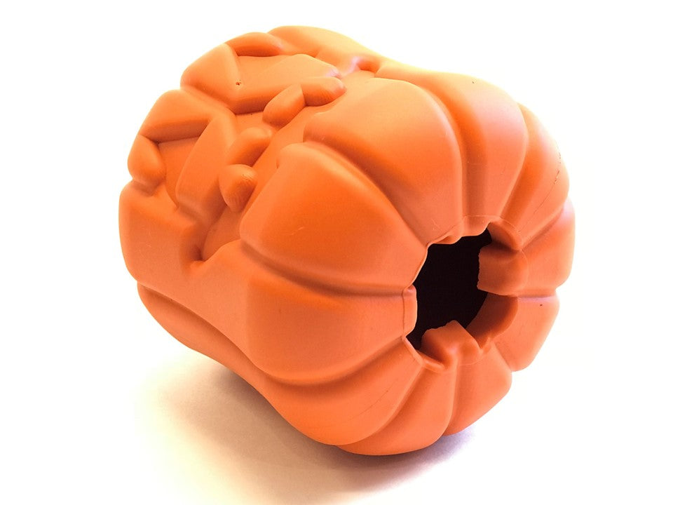 Orange jack-o'-lantern dog treat dispenser toy with side opening and carved ridges.