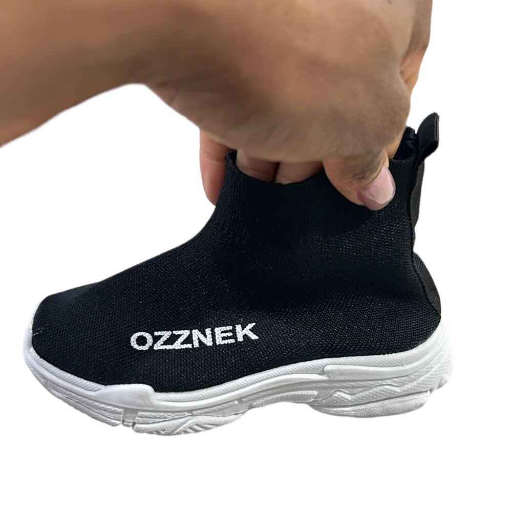 Kids slip-on sneaker, black knit upper with white sole and OZZNEK logo on side