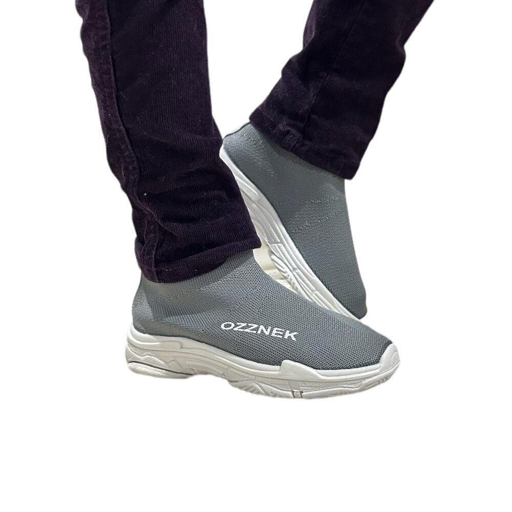 Kids slip-on sneakers on foot, light grey knit upper and white sole