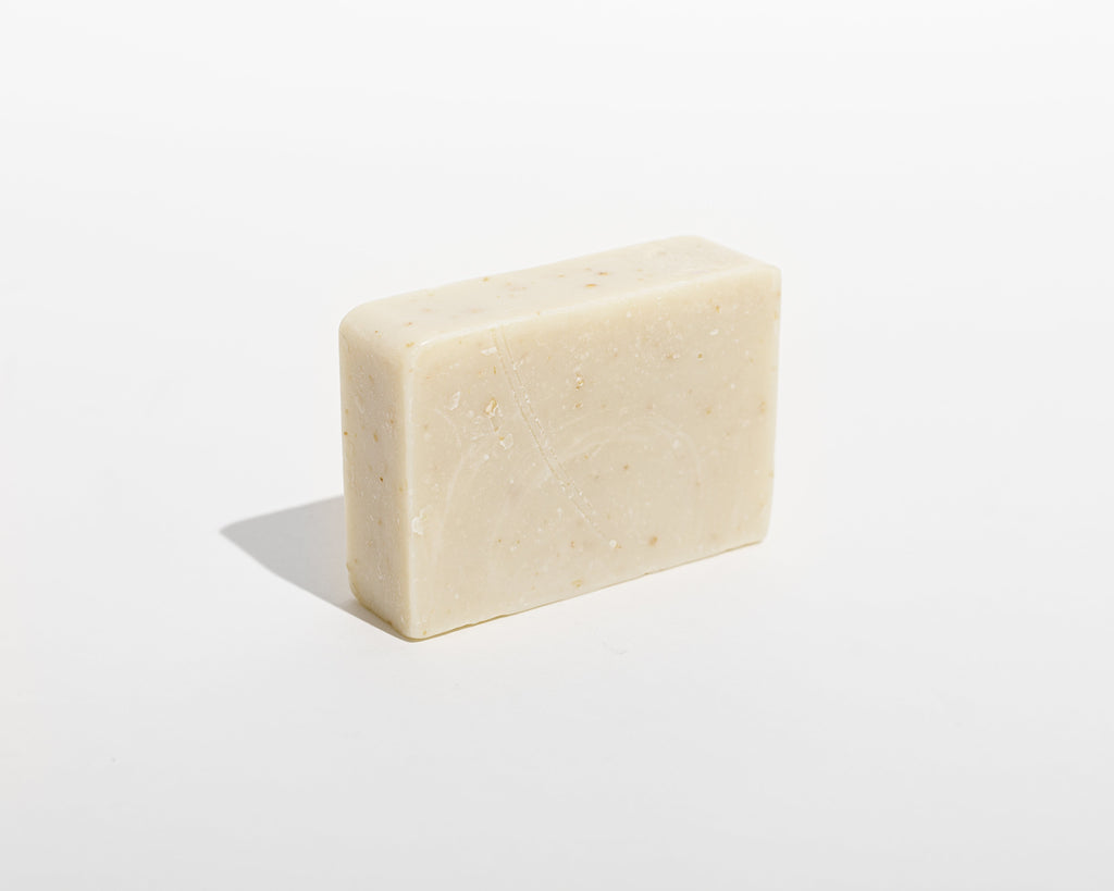 Cold-processed soap bar, light beige with small speckles, rectangular.