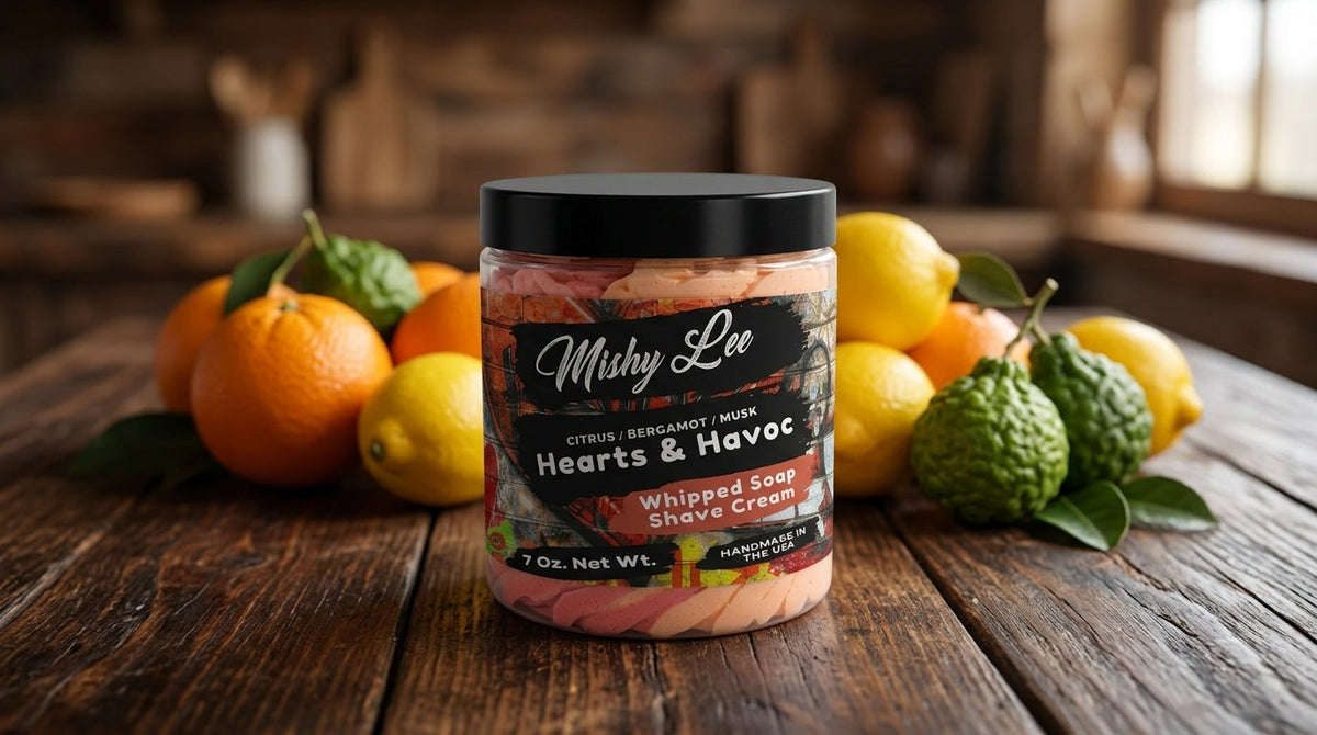 Whipped soap and shave cream jar on wooden table with citrus fruits, Hearts & Havoc label