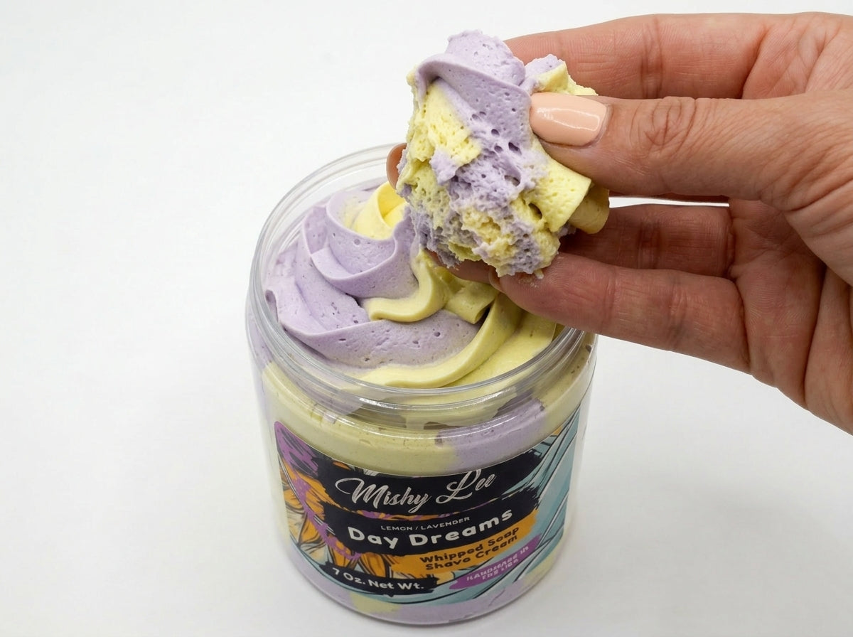 Hand holding scooped Day Dreams whipped soap with purple and yellow swirls