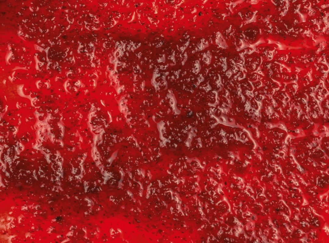 Red strawberry puree close-up with glossy thick texture