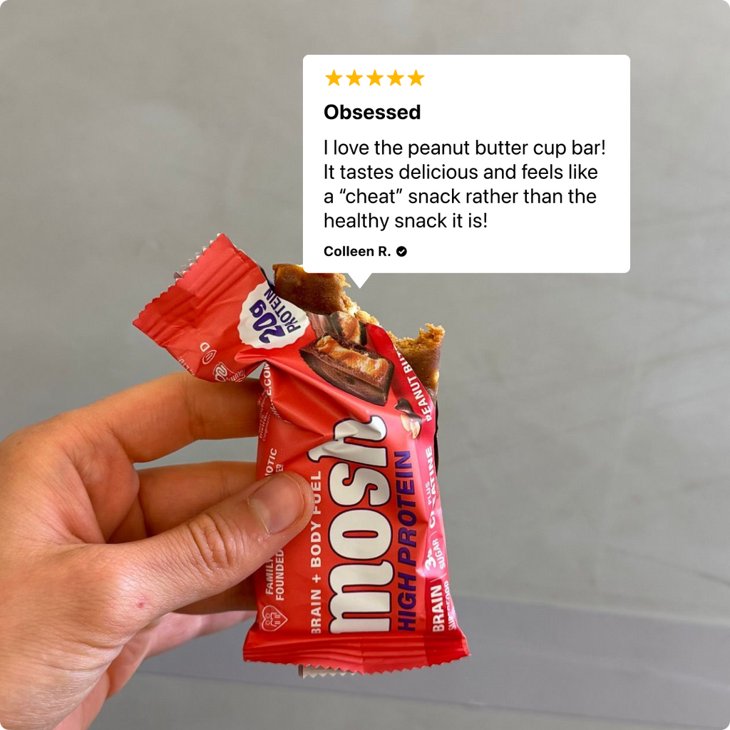 Hand holding a peanut butter cup high-protein bar