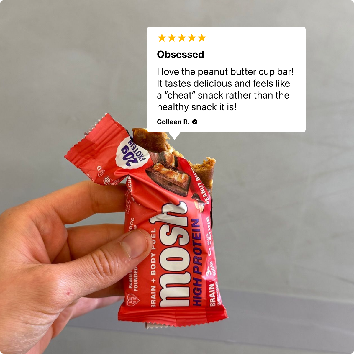 Hand holding a peanut butter cup high-protein bar
