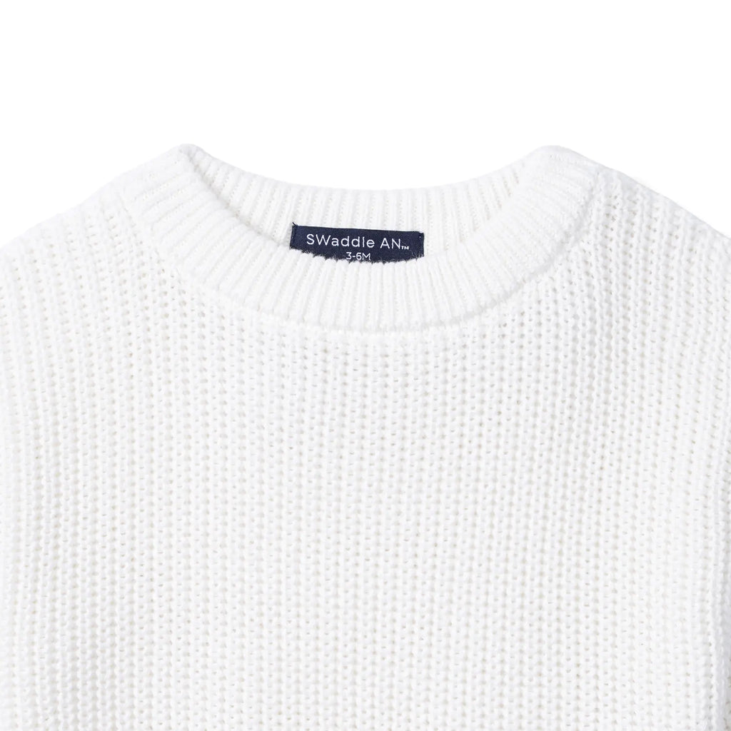 White chunky knit baby romper with ribbed crew neck and brand label at neckline