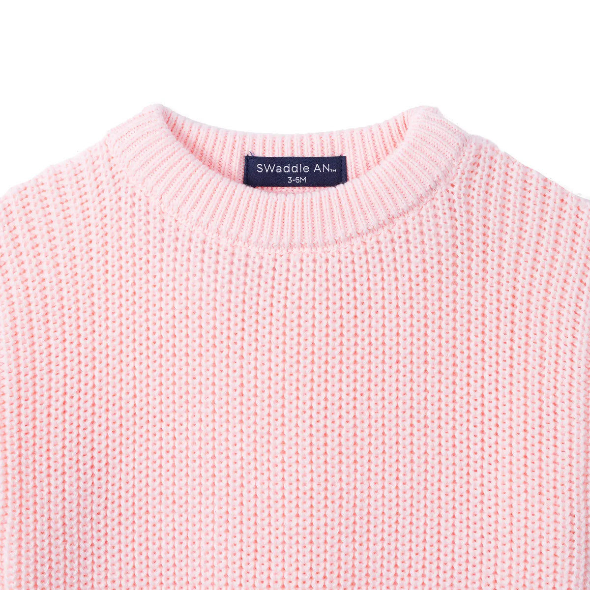 Pink chunky knit baby romper close-up with ribbed crew neck