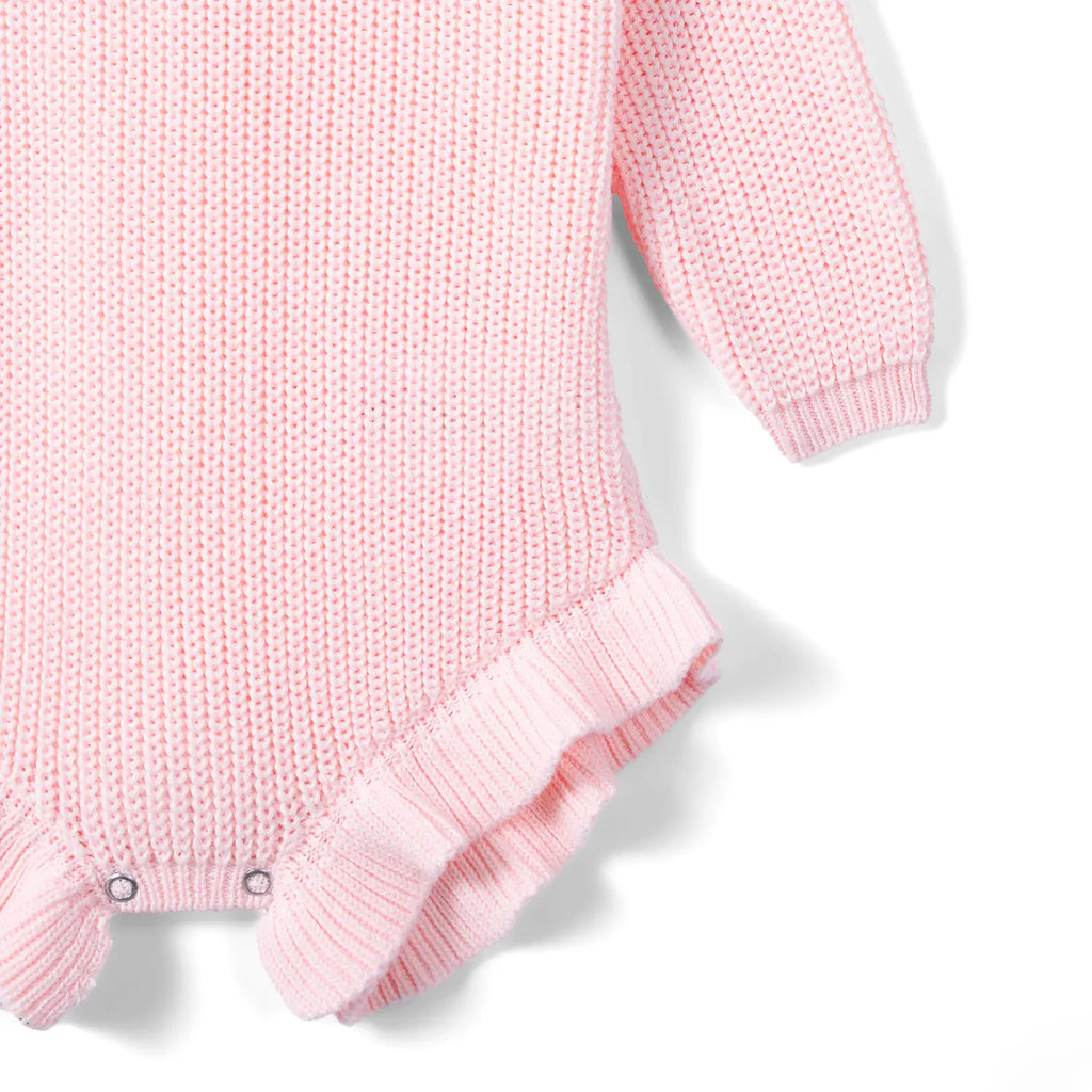 Pink knit romper bottom view with ruffled hem and snap buttons