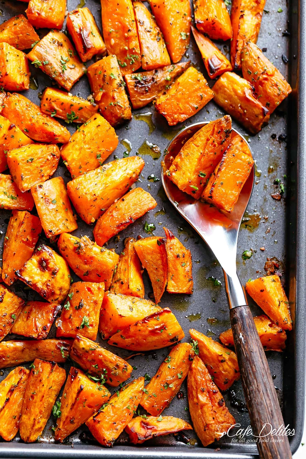 Roasted sweet potato cubes with seasoning on a baking tray