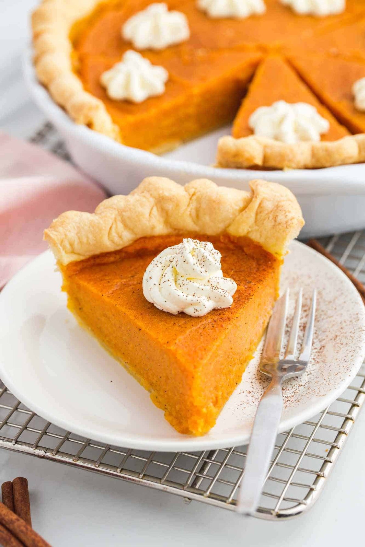 Sweet potato pie slice with whipped cream topping on a plate