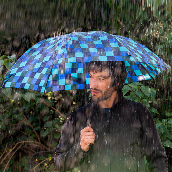 Blue checkered trekking umbrella with straight handle, open canopy for rainy hikes