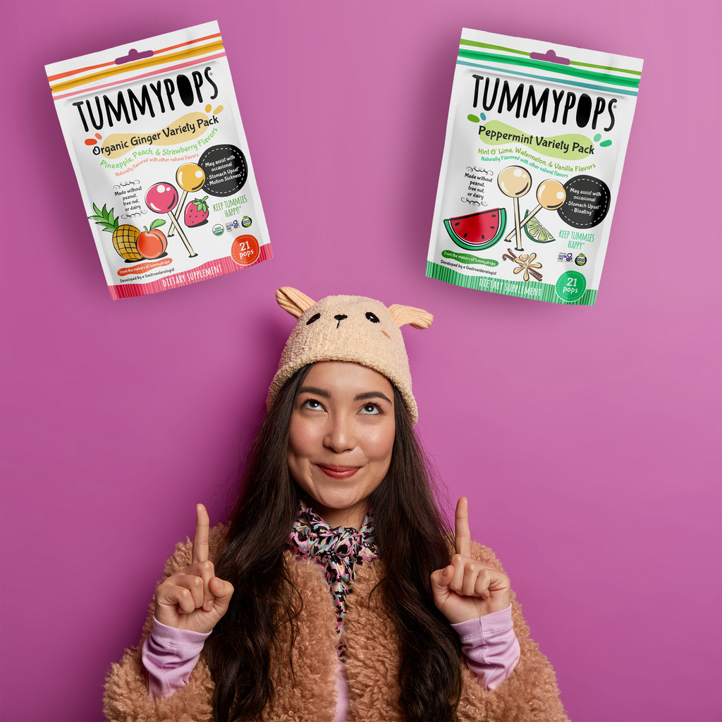 Two supplement variety pouches held by a person: organic ginger and peppermint