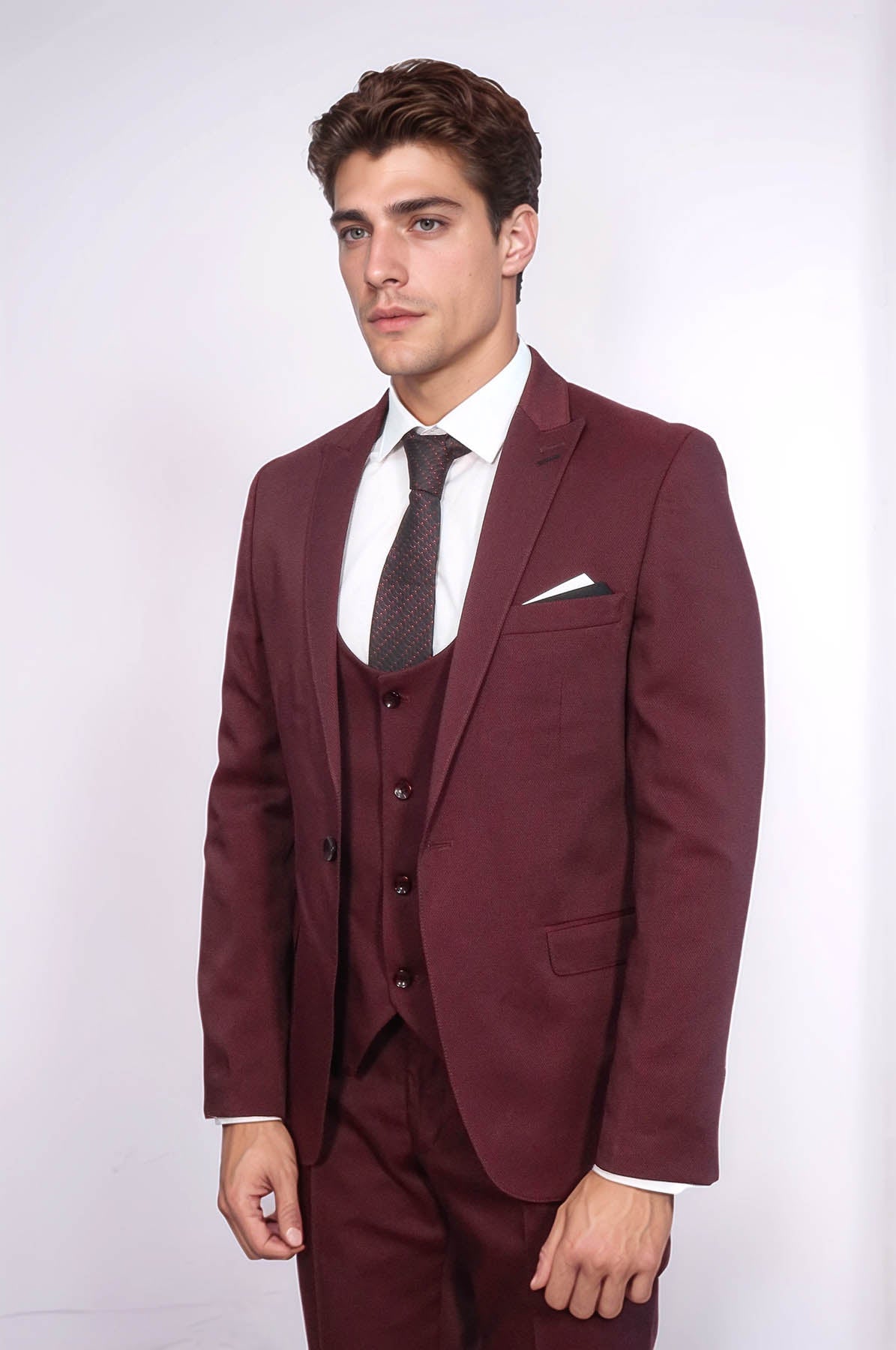 Burgundy three-piece suit with textured vest, jacket, dress shirt, and tie