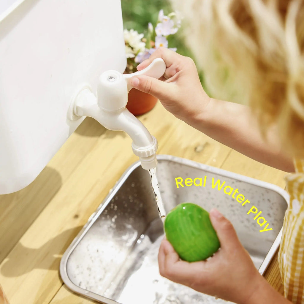 Hand turns faucet on kids mud kitchen water bin with green scoop and basin