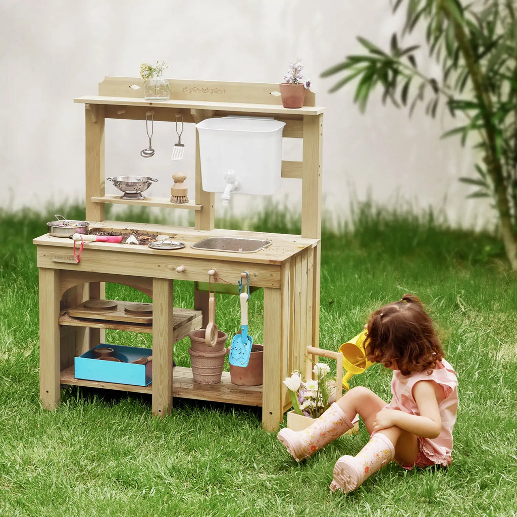 Kids beside outdoor wooden mud kitchen playset with storage shelves and water spout