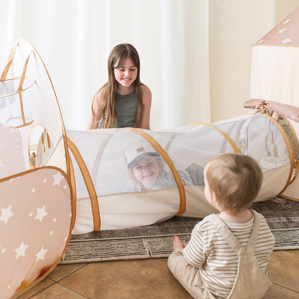 Light tan and white star-print play tunnel with arched entrance and open side panels