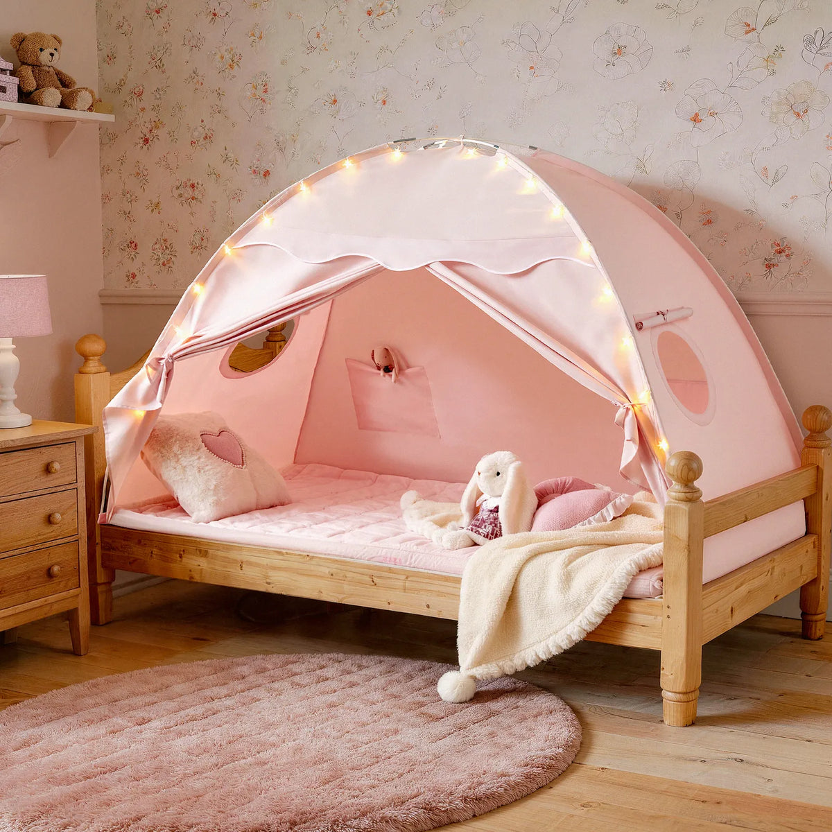 Pink kids bed tent with starry space print, rounded roof and glowing interior