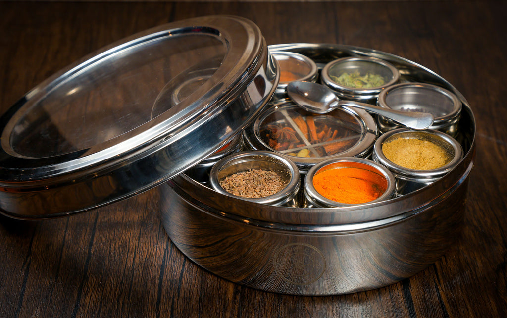 Stainless spice wheel tin with open lid and visible spice jars in round wells