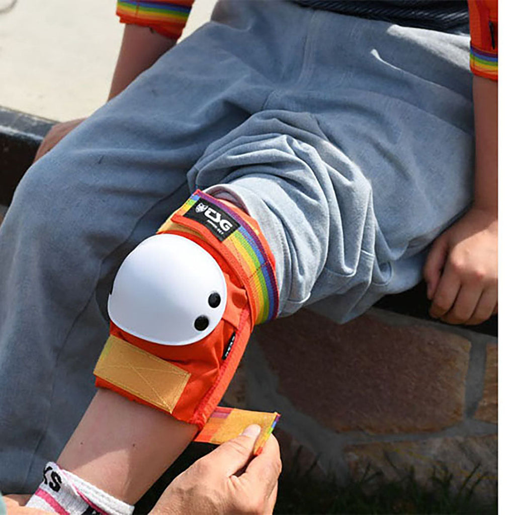 Close-up of colorful wrist guard with white hard-shell cap and orange strap