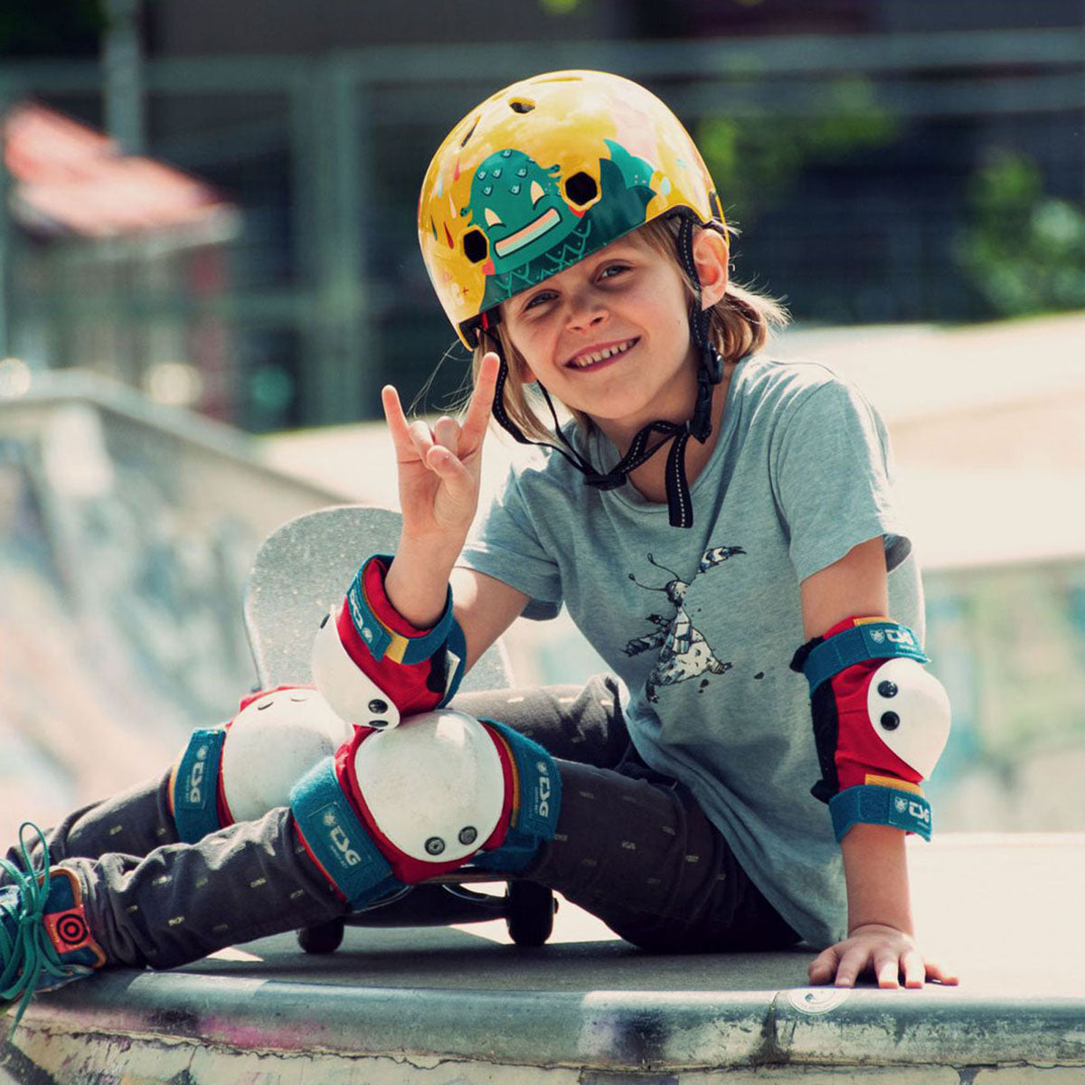 Child wearing colorful junior skate pad set on elbows, knees, and wrists