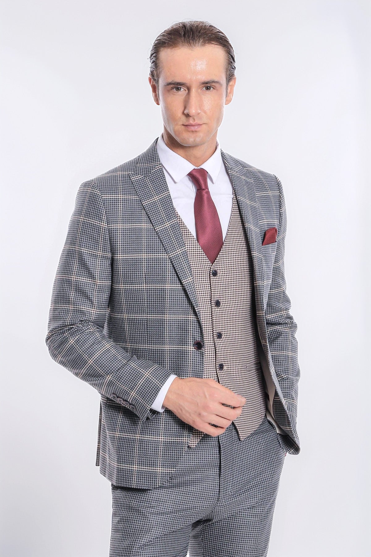 Three-piece checked grey suit with waistcoat, maroon tie, and red pocket square