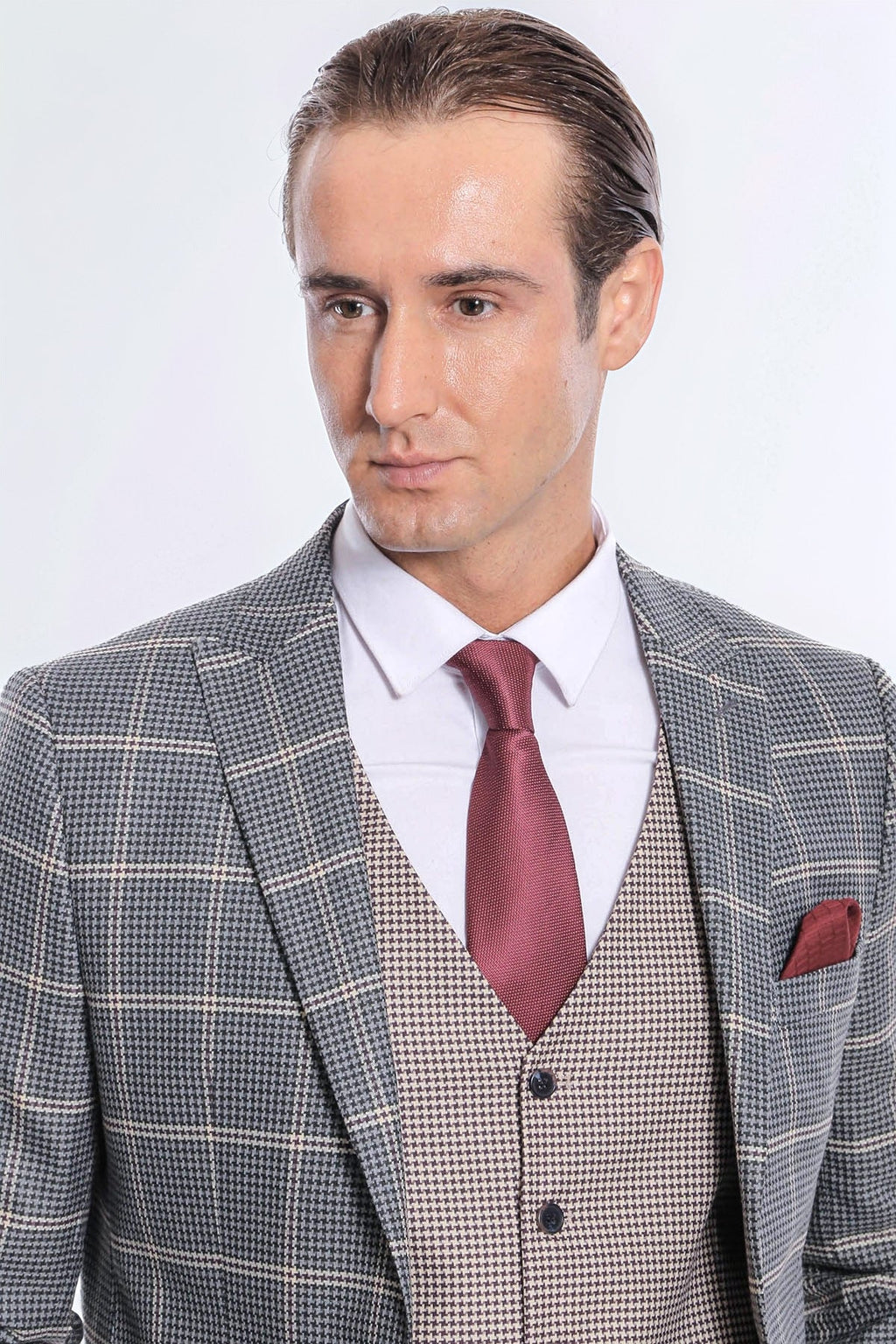 Checked grey suit jacket and waistcoat with maroon tie and red pocket square
