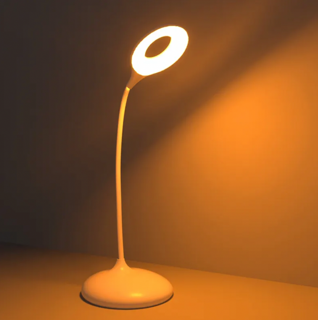 Amber glow bedside table lamp with curved neck and round base