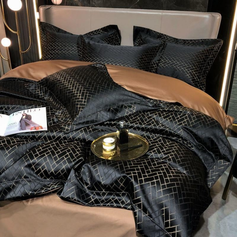 Black cotton satin bedding set with gold grid pattern and tan accent sheet over duvet