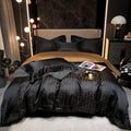 Black cotton satin bedding set with gold geometric grid pattern and matching pillowcases