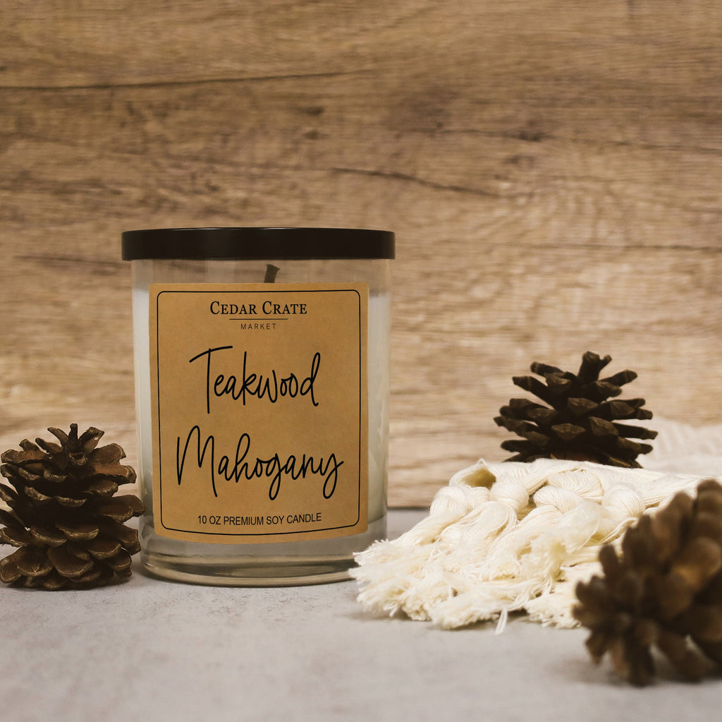 Front view Teakwood Mahogany soy candle in clear glass jar with black lid and kraft label