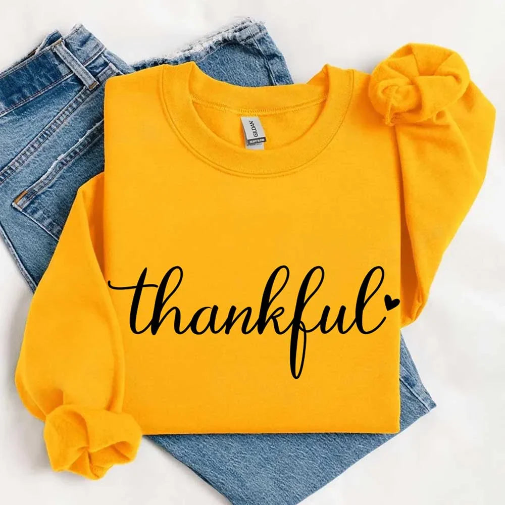 Mustard yellow sweatshirt with “thankful” script print and knotted sleeve cuff detail