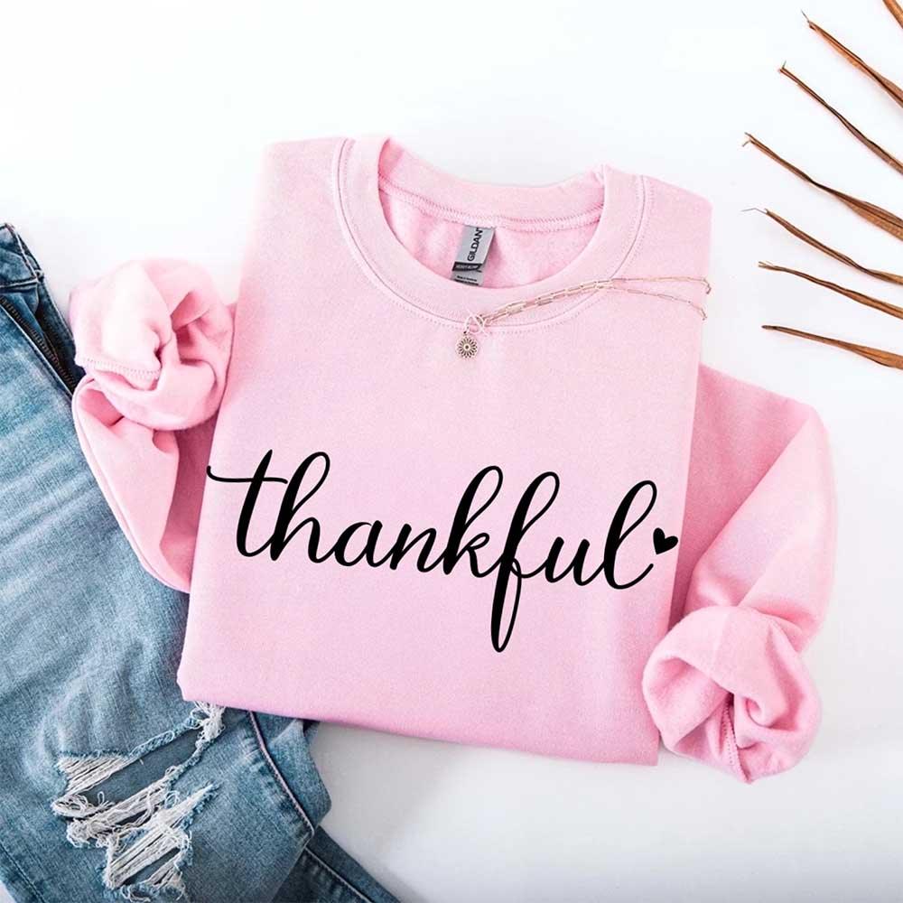 Pink women’s sweatshirt with “thankful” script print, crewneck and long sleeves