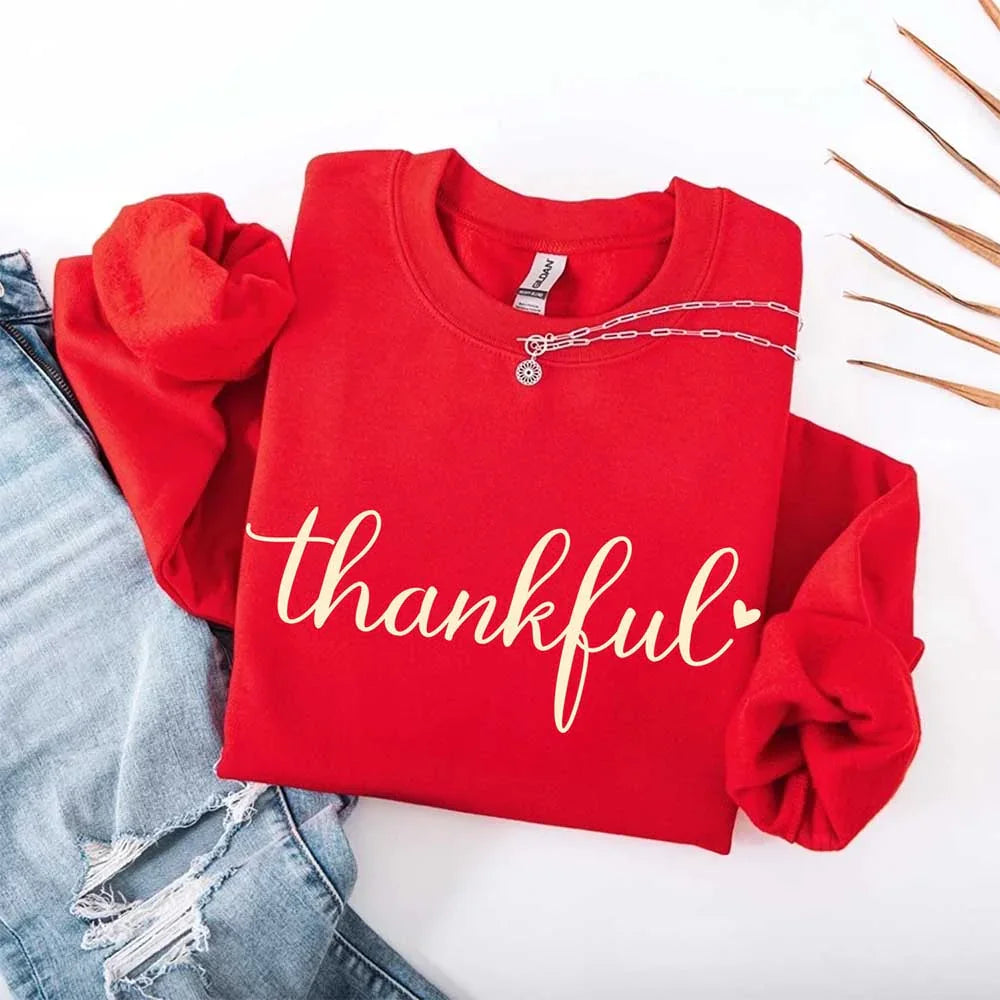 Red women’s sweatshirt with “thankful” script print, round neckline and long sleeves
