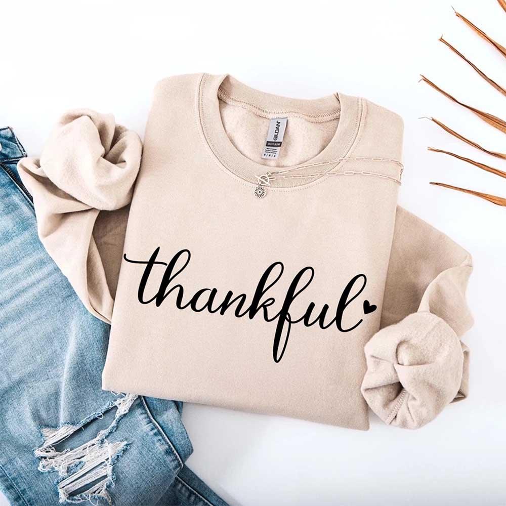 Tan women’s sweatshirt with “thankful” script print, crewneck and long sleeves