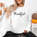 White crewneck sweatshirt with “thankful” script print and long sleeves