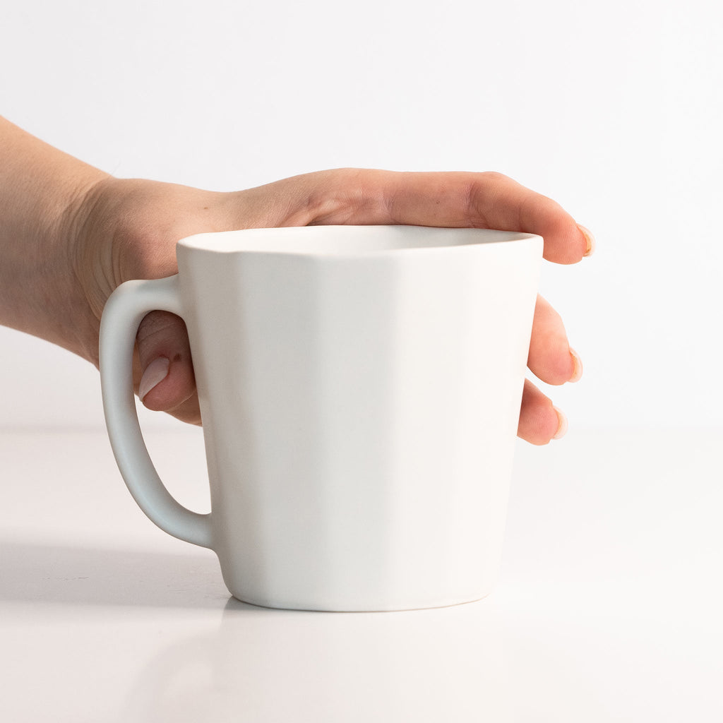 Handmade porcelain coffee mug, pale light gray-blue with C-shaped handle