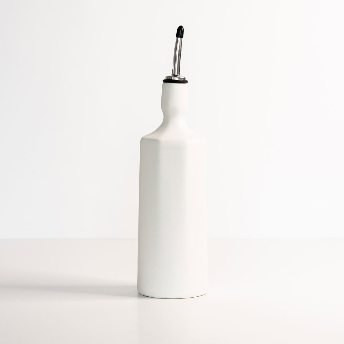 Porcelain olive oil dispenser in silk white with black pour spout and pump
