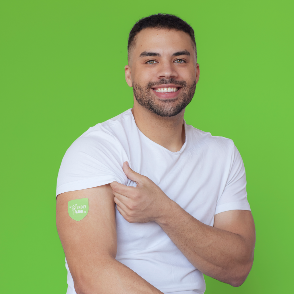 Small green vitamin patch applied to upper arm on a smiling person