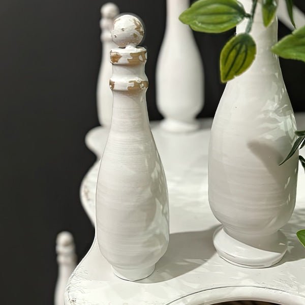 Decorative finial details and turned posts on white etagere shelf with vase display