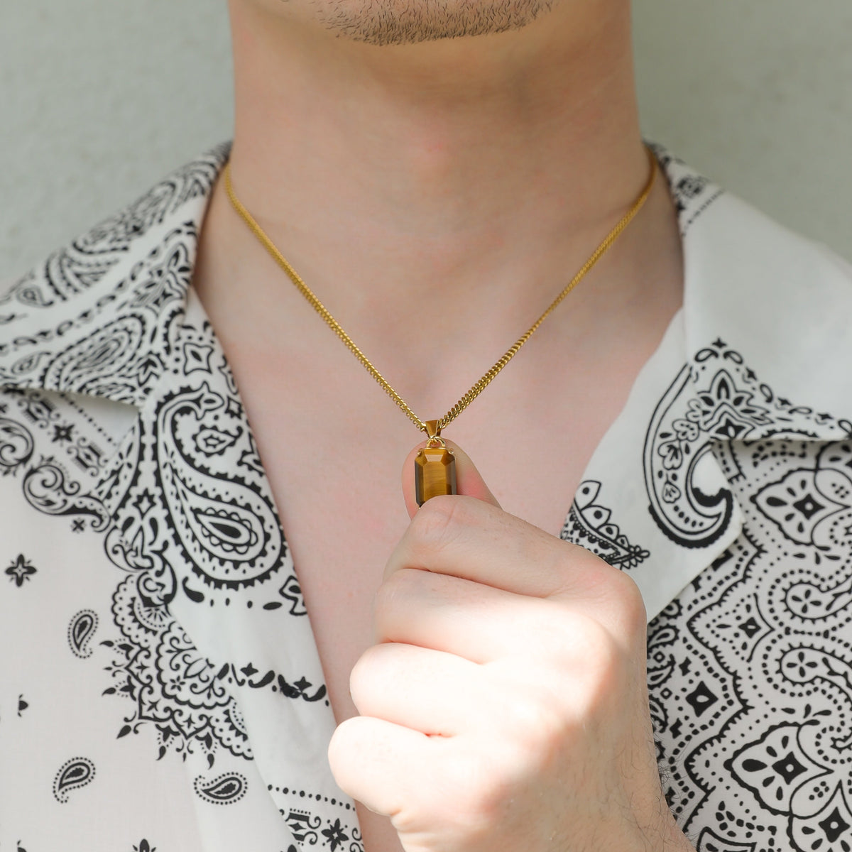 Gold-tone tiger eye pendant on chain with faceted rectangular stone