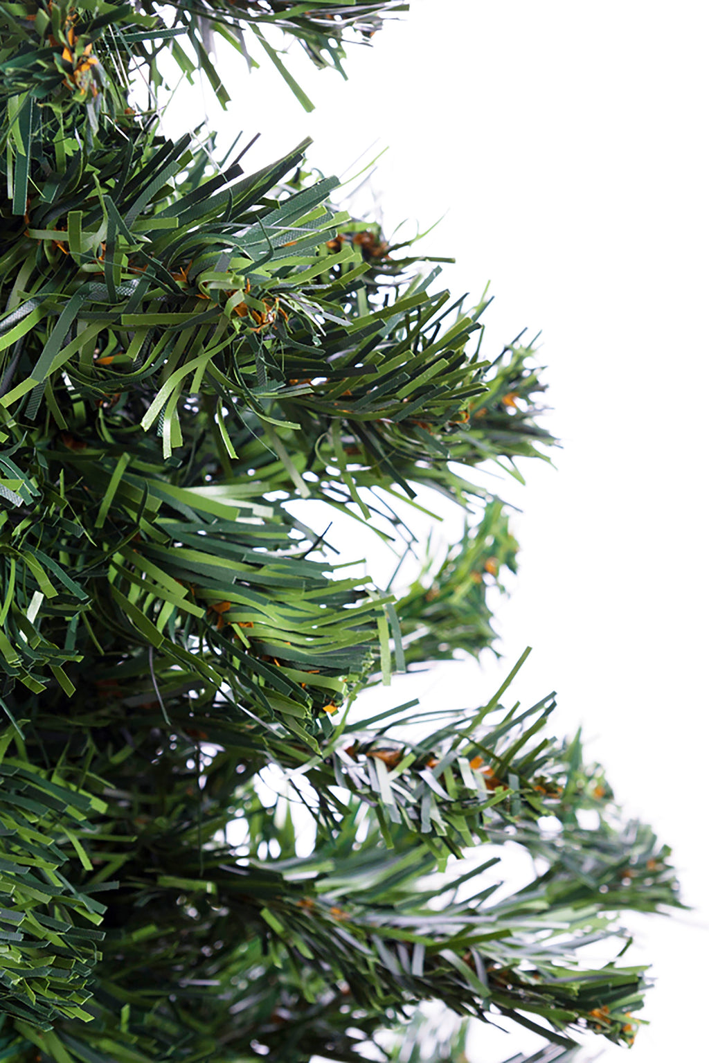 Green artificial Christmas tree branch tips close-up