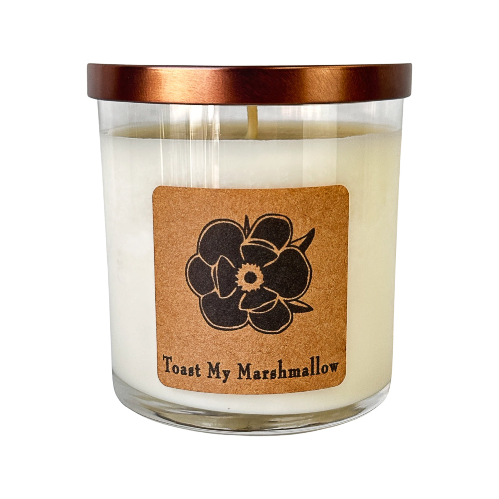 Soy candle in clear glass jar with copper lid, cream wax and floral label