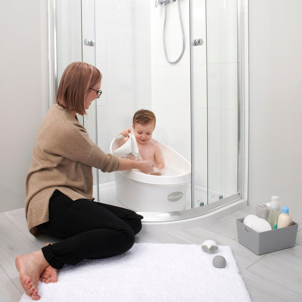 Toddler bath tub with white backrest, used inside a shower with a seated child